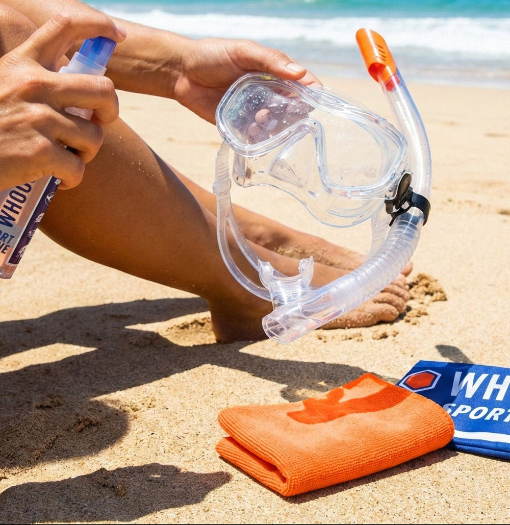 Person cleaning their snorkeling gear on a beach with Whoosh Sport Shine spray 30mL/1oz.